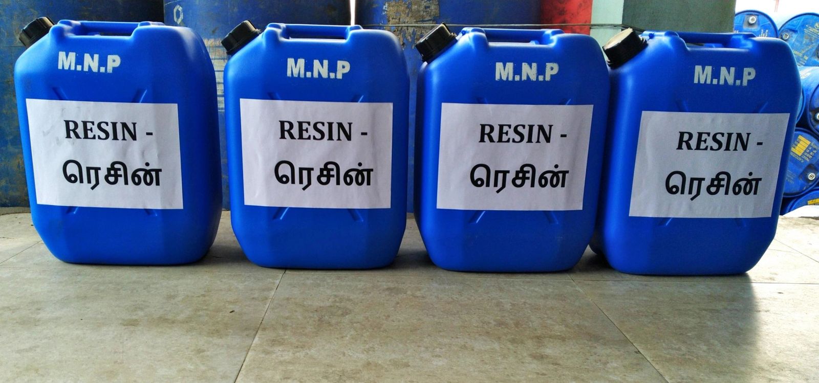 Four blue M.N.P resin containers in a row.